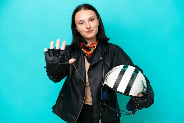 오토바이 헬멧을 코카서스 여성은 손가락 인푸른 배경에 고립되어 있었다 — 스톡 사진