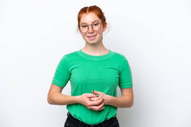 Kırmızımsı genç kadın beyaz arka planda yalnız gülüyor.