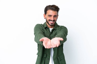 Beyaz arka planda izole edilmiş genç beyaz bir adam bir ilan vermek için avucunun içinde hayali bir fotokopi makinesi tutuyor.