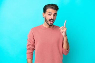 Kafkasyalı genç adam mavi arka planda izole edildi.