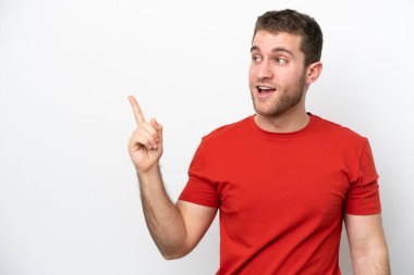 Beyaz arka planda izole edilmiş genç beyaz bir adam çözümü bulmak için parmağını kaldırıyor.