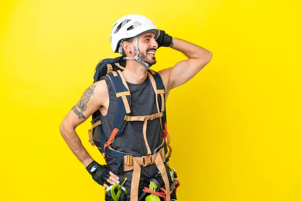 年轻的高加索攀岩者被隔离在黄色背景下 他发现了什么 并打算解决这个问题 — 图库照片