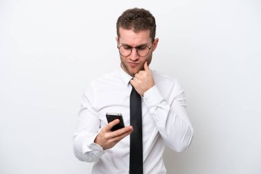 Genç beyaz iş adamı beyaz arka planda izole edilmiş düşünüyor ve bir mesaj gönderiyor.