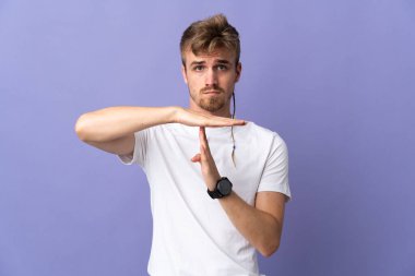 Mor arka planda izole edilmiş genç, sarışın bir adam.