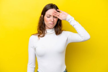 Sarı arka planda izole edilmiş, yorgun ve hasta bir ifadeyle genç beyaz bir kadın.