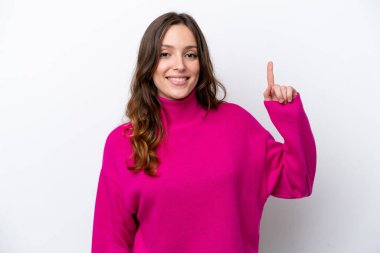 Beyaz arka planda izole edilmiş genç beyaz kadın en iyinin işareti olarak parmağını kaldırıyor ve gösteriyor.