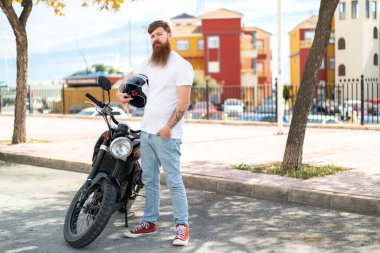 Motosikletli sakallı kızıl saçlı adam.