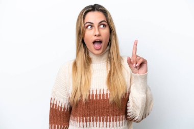 Beyaz arka planda izole edilmiş genç beyaz bir kadın, bir fikrin suçluyu işaret ettiğini düşünüyor.