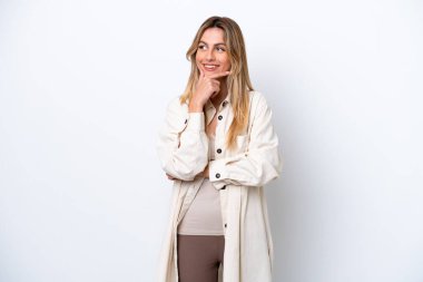 Young Uruguayan woman isolated on white background thinking an idea while looking up