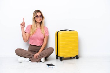 Uruguaylı gezgin kadın beyaz arka planda tek başına oturmuş işaret parmağıyla işaret ediyor. Harika bir fikir.