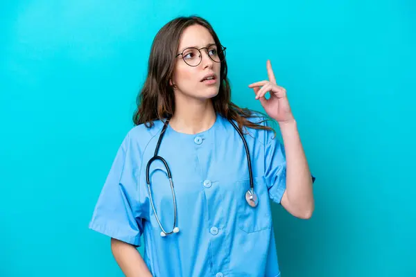Young Surgeon Doctor Woman Isolated Blue Background Thinking Idea Pointing — 图库照片