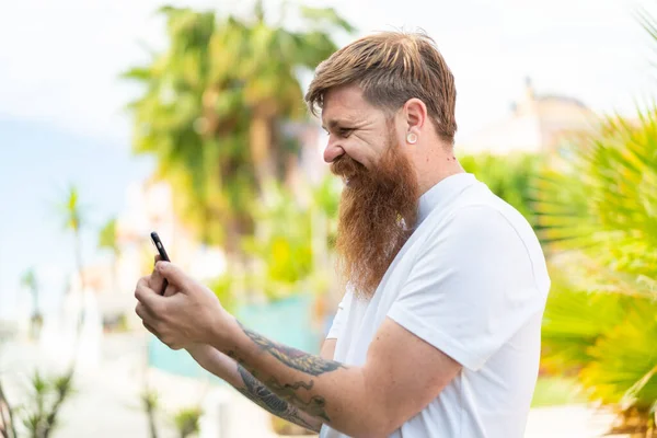 Sakallı Kızıl Saçlı Adam Cep Telefonuyla Mesaj Posta Yolluyor — Stok fotoğraf
