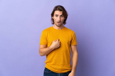 Mor arka planda soyutlanmış genç yakışıklı bir adam kendini gösteriyor.