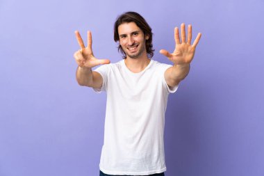 Mor arka planda izole edilmiş genç ve yakışıklı bir adam.