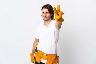 Arka planda yaşayan genç elektrikçi gülümsüyor ve zafer işareti gösteriyor.