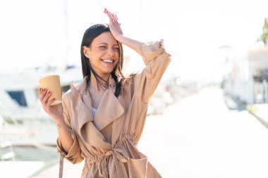 Açık havada elinde kahve tutan genç bir kadın bir şeyin farkına vardı ve çözüme niyetlendi.