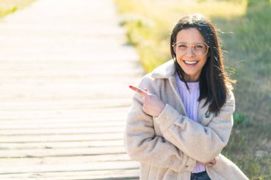 Dışarıdaki genç kadın Gözlüklü ve işaret eden tarafıyla