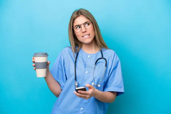 Junge Chirurgin Ärztin Isoliert Auf Blauem Hintergrund Mit Kaffee Zum — Stockfoto