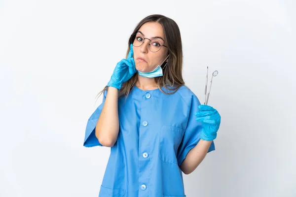 Kobieta Rumuński Dentysta Trzyma Narzędzia Izolowane Różowym Tle Myśląc Pomysł — Zdjęcie stockowe