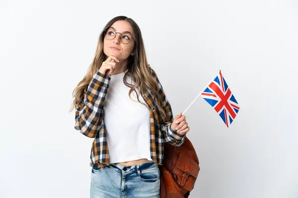 イギリスの国旗を掲げた若いルーマニア人女性が白い背景で孤立し 見上げる — ストック写真