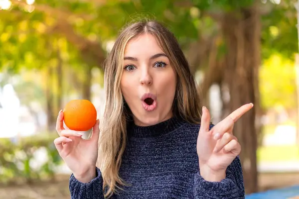 Jeune Jolie Roumaine Tenant Une Orange Extérieur Surpris Pointant Côté — Photo