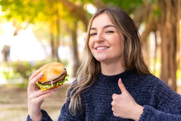Jeune Jolie Roumaine Tenant Hamburger Extérieur Avec Les Pouces Levés — Photo