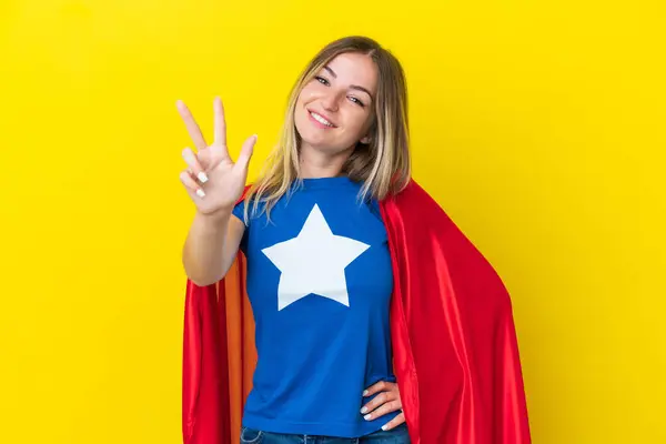 Super Hero Romanian woman isolated on yellow background happy and counting three with fingers
