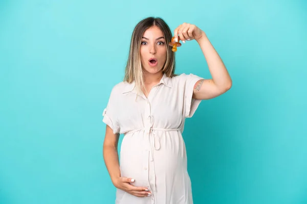 Young Romanian Woman Isolated Blue Background Pregnant Holding Pacifier Surprised — Stock Photo, Image