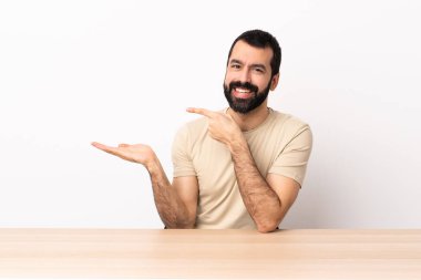 Masada sakallı, beyaz bir adam, bir ilan vermek için avucunda hayali bir fotokopi makinesi tutuyor..