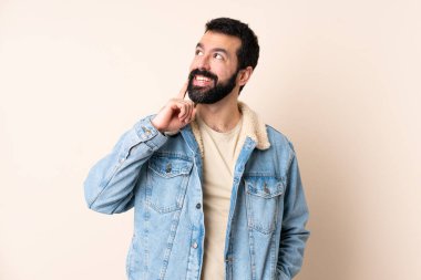 Kafkasyalı sakallı, soyutlanmış bir geçmişi olan bir adam yukarı bakarken bir fikir düşünüyor.