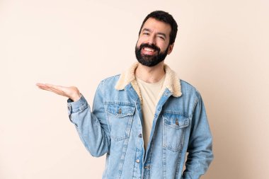 İzole edilmiş arka planda sakallı beyaz bir adam bir ilan vermek için avucunun içinde hayali bir fotokopi makinesi tutuyor.
