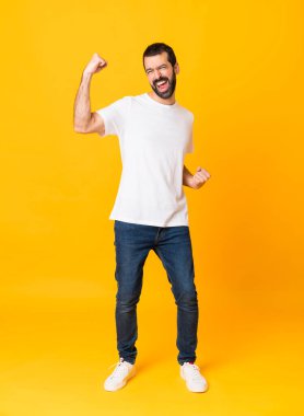 Sarı arka planda sakallı bir adam zaferi kutluyor.