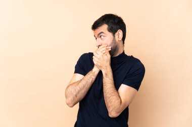 Kafkas yakışıklı adam izole edilmiş arka planda ağzını kapatıyor ve yana bakıyor.