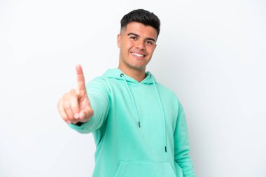 Beyaz arka planda izole edilmiş beyaz tenli yakışıklı bir adam parmağını kaldırıyor ve gösteriyor.