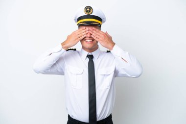 Uçak pilotu, beyaz arka planda izole edilmiş beyaz tenli, gözleri elleriyle kapatan bir adam.