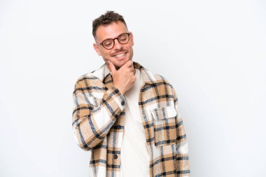 Beyaz arka planda soyutlanmış beyaz tenli yakışıklı bir adam yan tarafa bakıyor ve gülümsüyor.