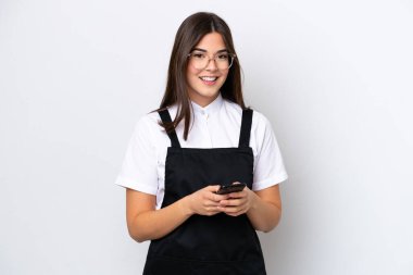 Brezilyalı garson kadın beyaz arka planda izole edilmiş cep telefonuyla mesaj yolluyor.
