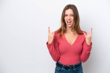 Beyaz arka planda izole edilmiş genç beyaz kadın boynuz hareketi yapıyor.