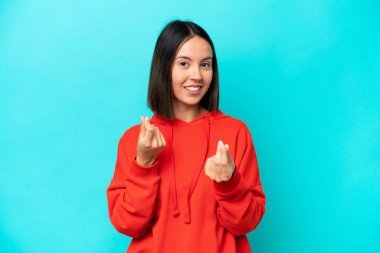 Kafkasyalı genç bir kadın mavi arka planda izole edilmiş para hareketi yapıyor ama mahvolmuş.