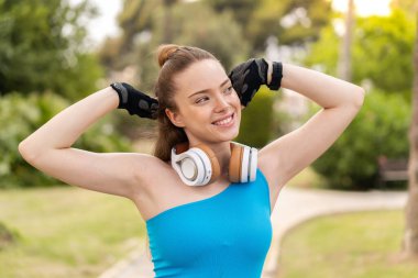 Açık havada genç ve güzel bir kız spor bir elbise giyiyor.