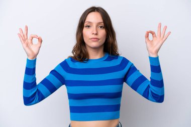 Beyaz arka planda Zen pozisyonunda beyaz tenli genç bir kadın.