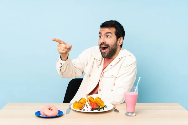 Man Vid Ett Bord Med Frukost Våfflor Och Milkshake Pekar — Stockfoto