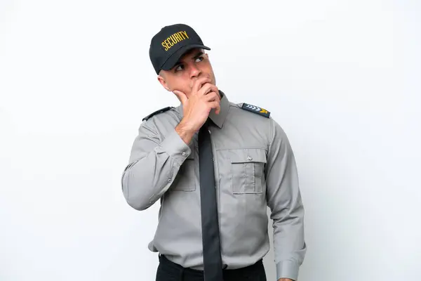 Young caucasian security man isolated on white background having doubts and with confuse face expression