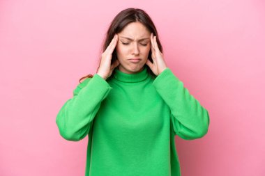 Pembe arka planda izole edilmiş, başı ağrıyan beyaz bir kadın.