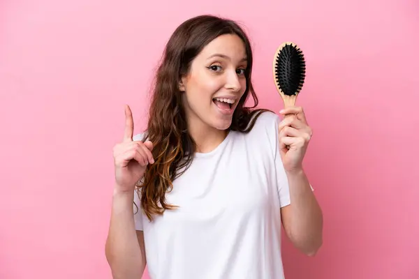 Young Caucasian Woman Hair Comb Isolated Pink Background Pointing Great — Stock Photo, Image