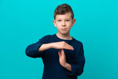 Küçük çocuk mavi arka planda izole edilmiş bir şekilde zaman geçiriyor.