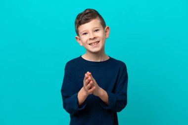 Küçük çocuk mavi arka planda izole edilmiş bir şekilde bir konferanstan sonra alkışlıyor.