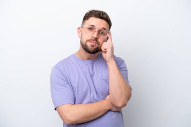 Beyaz arka planda izole edilmiş genç beyaz bir adam bir fikir düşünüyor.