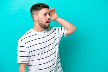 Mavi arka planda mahsur kalmış beyaz bir genç var.