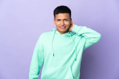 Genç Ekvadorlu adam, mor arka planda izole edilmiş gülüyor.